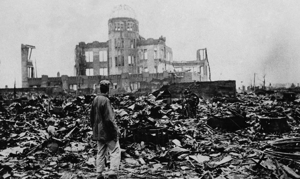 Homem parado diante de um edifício destruído em Hiroshima